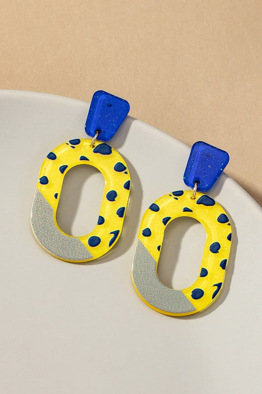 yellow, blue and black cutout oval hoop earrings with glitter background and color blocks